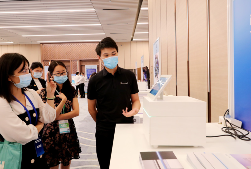 第四屆進(jìn)博會(huì)食品及農(nóng)產(chǎn)品展區(qū)、醫(yī)療器械及醫(yī)藥保健展區(qū)展前供需對(duì)接會(huì)的工作人員在介紹一臺(tái)測(cè)序儀展品